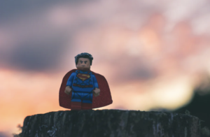 夕暮れ雲をバックに佇むスーパーマンのフィギュア